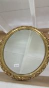 An oval gilt framed mirror.