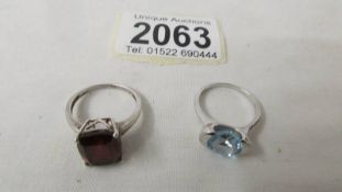 A silver ring set garnet, size N and a silver ring set topaz, size M.