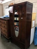 A 1930's oak wardrobe with oval bevel edge mirrored door Height 185cm, width 89cm,