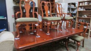 A mahogany extending dining table with 2 leaves and 8 dining chairs.