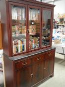 A mahogany veneered cabinet with glazed top.