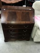 A mahogany effect bureau with string inlay and red leather writing surface height 95cm, width 75cm,