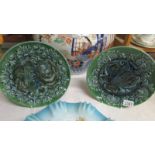 A pair of C H Brannam, Baram 1898 decorative plates in relief, 10" diameter, a/f.