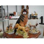 A large German Shepherd and three other dog figures.