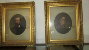 A pair of oval gilt framed portraits of a lady and a gentleman.