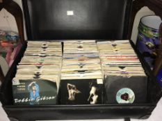 A box of 45rpm records including Billy Bragg, Radio 1, Jason Donovan,