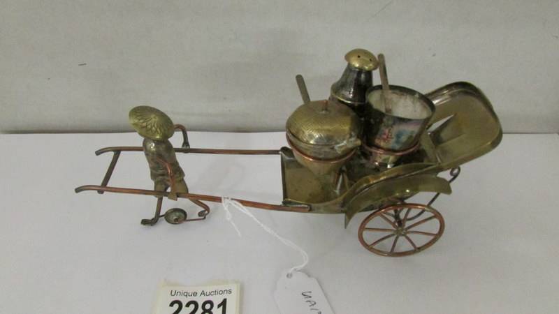 A nickel plated condiment set in the form of a rickshaw pulled by a Chinese man.