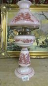 A lovely pink glass oil lamp decorated with birds and complete with original shade and chimney.