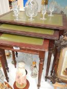 A nest of tables with leather inset tops.