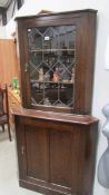 A dark oak corner cabinet with leaded glass door, 90 cm wide x 179 cm high.