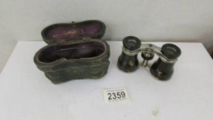 An original cased pair of Heinemann & Co., opera glasses.