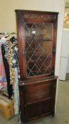 A dark oak corner cupboard with leaded glass door, 69 cm wide x 183 cm tall.