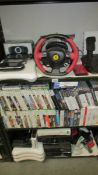 Three shelves of Xbox, Playstation and Nintendo games and consoles.