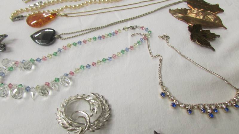 A mixed lot of costume jewellery including pendants, necklaces and brooches. - Image 4 of 6