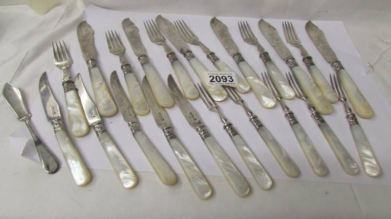 A set of fish knives and forks with mother of pearl handles and silver bands together with other