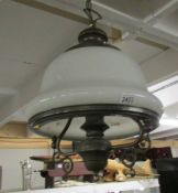 A vintage brass ceiling light with white glass shade.