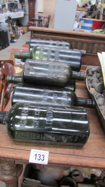 A quantity of named green glass bottles.