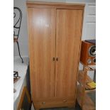 A two door wardrobe with single drawer.