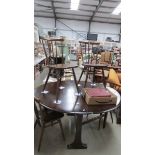 A dark Ercol drop leaf table and 4 chiars, 126 cm diameter x 72 cm high.