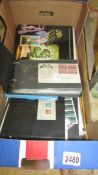 A box of USA stamps including mint year sets (7) sheets plus first day covers.