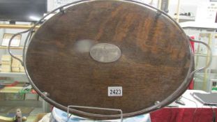 An oval oak tray with plated fittings.