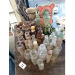 A lot of brown, green & clear small potion bottles with a jug etc.