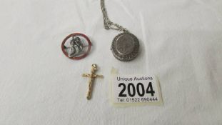 A gold crucifix, a silver locket on white metal chain and a silver mermaid brooch.