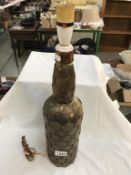 A large vintage bottle decorated with copper penny's & half pennies etc.