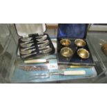 A cased set of 4 salts, a cased set of desert forks and a cased carving set.