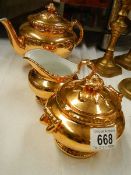 A three piece Royal Worcester gilded tea set.