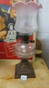 A Victorian oil lamp on cast iron base with glass font,