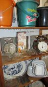 Five shelves of assorted kitchen ware including enamel cooking pots, glass tureens, jelly moulds,