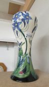 A large Moorcroft vase decorated with blue flowers, second quality, firing crack to base,