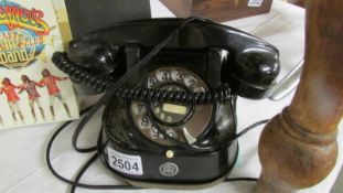 An early 20th century black dial telephone.