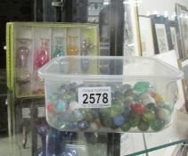 A quantity of glass marbles and five glass scent bottles.