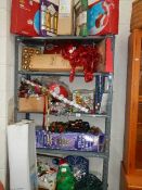 Five shelves of Christmas decorations including tree.