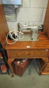 A vintage table Pfaff 30 sewing machine on Queen Anne legs.