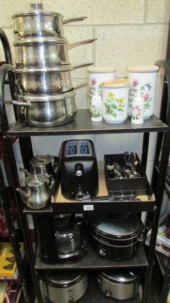 Four shelved of kitchen ware including 3 slow cookers, stainless steel pans etc.
