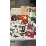 A selection of copies of German WW2 Nazi era badges etc., together with a quantity of cloth patches.