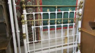 A 4' 6" brass and iron bedstead complete with side rails.
