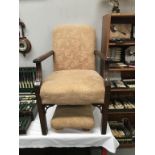 A vintage armchair with matching foot stool