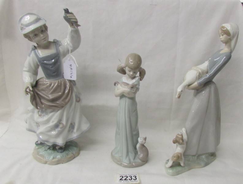 Three Lladro figures - Girl with goose and dog, girl with kittens and girl with bird.