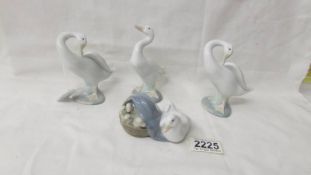 A Lladro duck with ducklings and three other Lladro ducks.