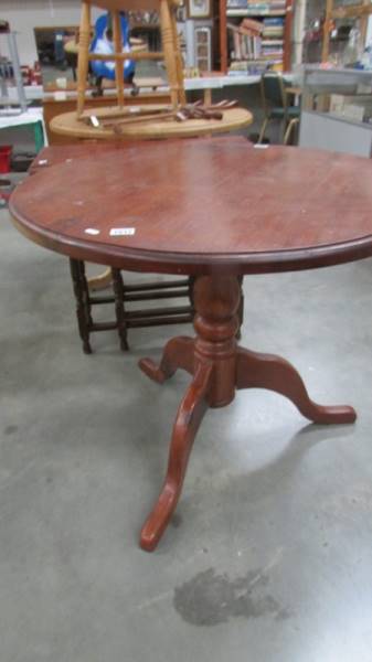 A dark stained pine circular kitchen table, 90 cm diameter, 77 cm high.