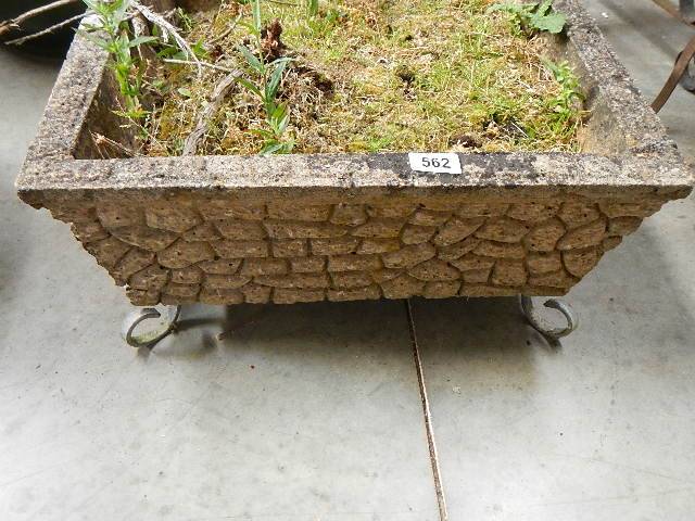 A good old square garden planter on metal feet.