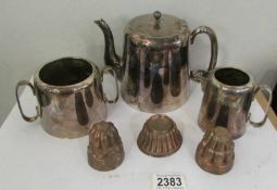 A silver plate three piece tea set and three small copper jelly moulds.