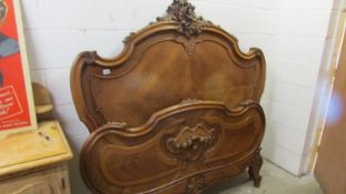 A carved French bedstead (no side rails, head and foot only).