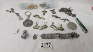 A £5 coin, military badges etc., An Eiffel tower bracelet.