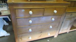 An old pine chest of drawers with ceramic knobs.
