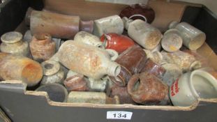 A box of stoneware bottles and jars.